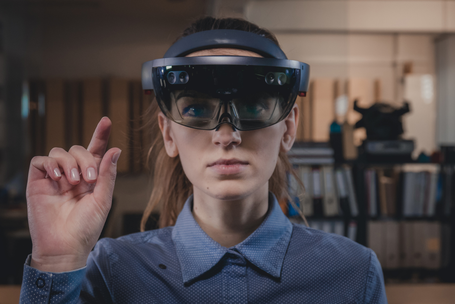Portrait of young Caucasian female using augmented reality holographic hololens in modern office