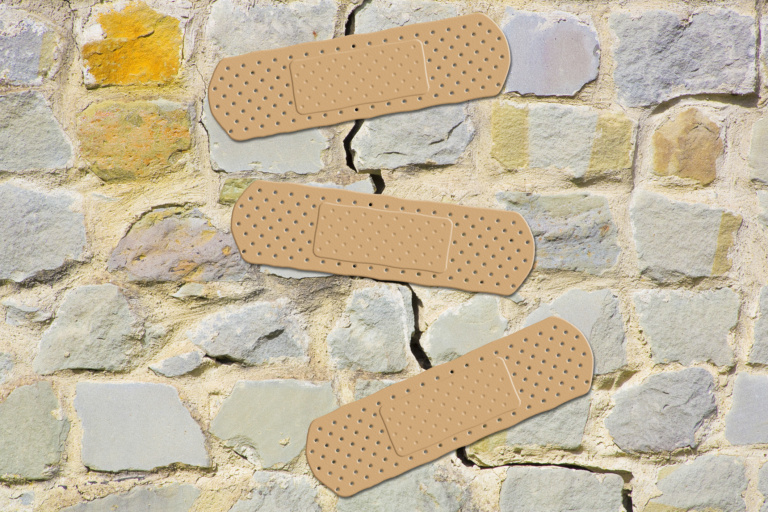 Old Cracked And Damaged Stone Wall Cause Due To Subsidence Of Foundations Structural Failures Concept With Adhesive Bandage
